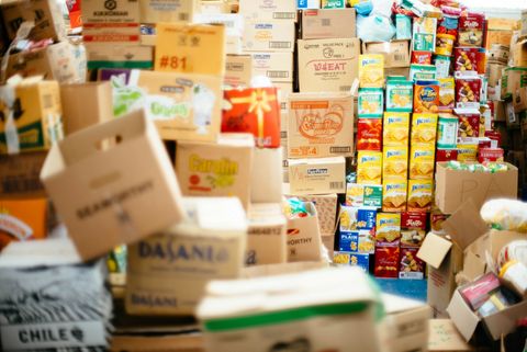 Stacks of a variety of cardboard and food boxes, some leaning precariously.
